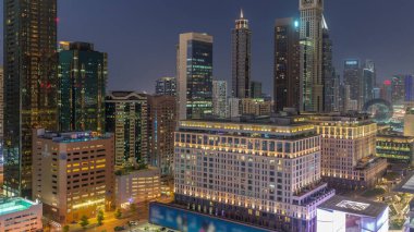 Dubai Uluslararası Finans Bölgesi, günden geceye geçiş zamanı. Gün batımından sonra iş yerinin gökyüzü manzarası. Şehir merkezine yakın otelleri olan gökdelenler.