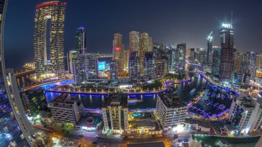 Dubai Marina 'nın panoramik manzarası. Limanda birkaç tekne ve yatlar var. Kanal anteninin etrafındaki gökdelenler. Arka planda JBR bölgesi kuleleri