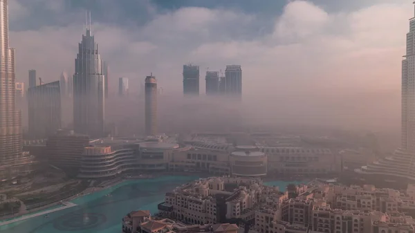 空中的晨雾覆盖了迪拜国际金融中心区的时间 日出时带现代摩天大楼和购物中心的写字楼和酒店 — 图库照片
