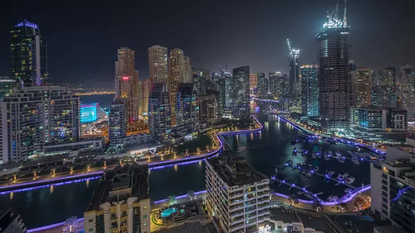 全景显示迪拜码头摩天大楼和Jbr区的豪华建筑和度假胜地的空中夜间时间 发光的海滨和漂浮在运河中的船只 — 图库照片