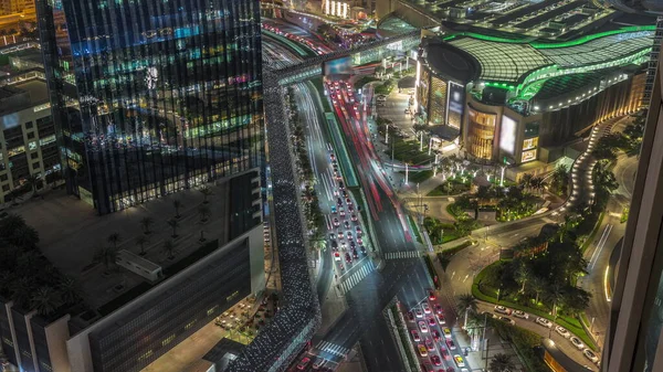 Aerial panorama of Downtown Dubai with shopping mall and traffic on a street day to night transition timelapse from above, UAE Modern skyscrapers and hotels