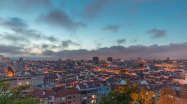 Panorama, Lizbon şehir merkezinin hava görüntüsünü gösteriyor. Gündüzden geceye geçiş zamanı, Portekiz. Eski şehir siluetindeki tipik evlerin kırmızı çatıları. Başkentte gün batımından sonra tarihi bölge
