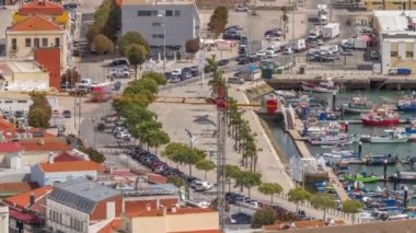 Portekiz, Setubal 'deki marina ve şehir merkezinin hava görüntüsü. Kırmızı çatılar ve kıyı şeridi yukarıdan gelen tekne ve gemilerle. Yolda trafik vardı.