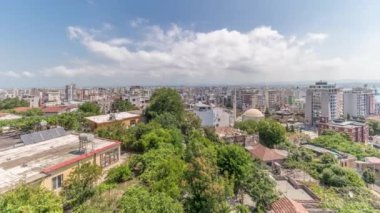 Panorama, eski kent merkezinin hava manzarasını ve Arnavutluk 'un Durres limanının zaman çizelgesini gösteriyor. Gökyüzünde bulutlar olan, kırmızı çatıları ve yeşil ağaçları olan birçok ev.