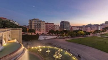 Panorama Alameda Dom Afonso Henriques 'in çimlerini renkli binalar ve aydınlatılmış Aydınlık Çeşme havadan geceye geçiş süresini gösteriyor Lizbon, Portekiz' de gün batımından sonra yukarıdan