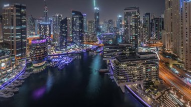 Panorama Dubai marinasının hava manzarasını gösteriyor. Kanal çevresindeki gökdelenler yüzen yatlarla aydınlatılıyor. Jlt ve JBR bölgelerindeki kuleler. Yat kulübünde beyaz tekneler var.