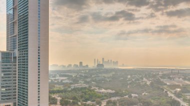 Sunrise over garden in Zabeel district with skyscrapers on a background aerial in Dubai, UAE. Orange clouds on the sky with rays of sun light