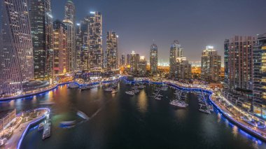 Dubai marinası en uzun gökdelenler ve yatlar liman havasından geceye gün batımından sonra geçiş. Apartman binalarına, otellere ve ofis bloklarına, BAE 'nin modern yerleşim alanlarına bak