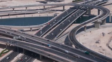 Aerial top view of busy traffic on Dubai highway urban and modern transportration concept. Cars driving on junction and overpass at business bay canal