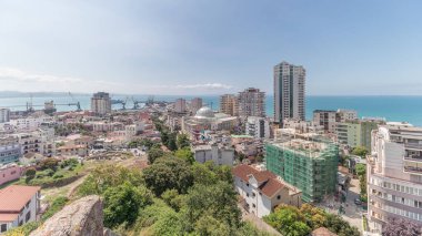 Panorama, Arnavutluk 'un Durres limanı ve şehir merkezinin (eski kent) hava manzarasını gösteriyor. Gökyüzünde bulutlar olan yeşil ağaçlı birçok ev