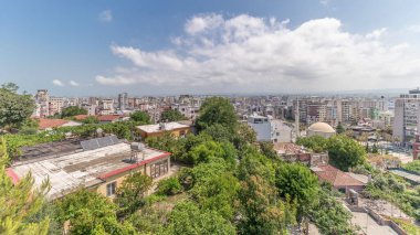 Panorama, Arnavutluk 'un Durres limanı ve şehir merkezinin (eski kent) hava manzarasını gösteriyor. Gökyüzünde bulutlar olan, kırmızı çatıları ve yeşil ağaçları olan birçok ev.
