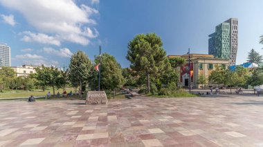 Arnavutluk 'un Tiran kentinin ana meydanında Skanderbeg anıtı ve Ethem Bey camisini gösteren panorama. Parktaki yeşil ağaçlar ve etraftaki gökdelenler