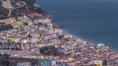 Atlantik Okyanusu 'nun ortasındaki Susimbra Köyü' nün kıyı şeridinin hava görüntüsü. Kale 'nin bakış açısından aydınlatılmış evlerle dolu bir akşam. Portekiz