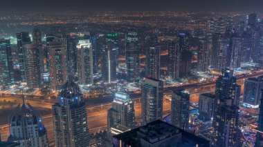 Şeyh Zayed Yolu yakınlarındaki JLT ve Dubai marina gökdelenleri. Aydınlatılmış konut binaları ve karayolu trafiği