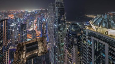 Panorama, Dubai Marina 'yı JLT ve JBR bölgesiyle gösteriyor. Gökdelenler arası karayolunda trafik vardı. Aydınlatılmış modern kuleler ve inşaat alanı