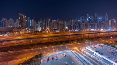 Dubai marinasının panoraması tüm gece boyunca en yüksek gökdelen bloğu ve ışıkları kapalıydı. JLT bölgesinden apartman binalarına, otellere ve otoyol yakınlarındaki iş kulelerine hava manzarası.