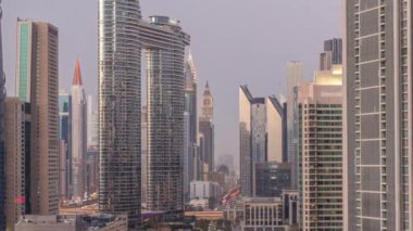 Günbatımından sonra Dubai şehir merkezinde ve finans bölgesinde caddelerde trafik olan fütürist kuleler ve gökdelenler. Şehir silueti gökyüzü günden geceye geçiş zamanı yukarıdan