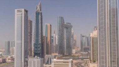Tüm gün boyunca Dubai şehir merkezinde ve finans bölgesinde caddelerde trafik olan fütürist kuleler ve gökdelenler. Şehir silüeti, gölgelerle birlikte gün batımına kadar hızla hareket ediyor.