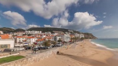 Panorama, Portekiz 'de Sesimbra Kasabası' nın ve deniz kıyısında yürüyüş zamanının hava görüntüsünü gösteriyor. Evleri ve kaleden kumsalları olan bir yer. Setubal ilçesinde tatil köyü