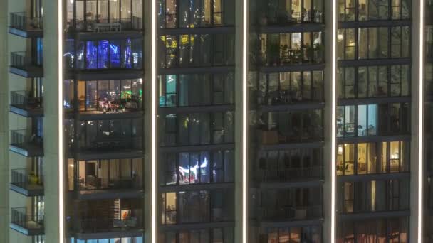 位于城市航时时区住宅区的大块带发光全景窗的公寓 塔楼和摩天大楼里的房间里的夜光 — 图库视频影像