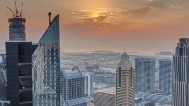Dubai 'deki Sheikh Zayed Yolu' ndaki yüksek binalar. Gün batımında uluslararası finans bölgesinde gökdelenler. Arka planda evler ve villalar var.