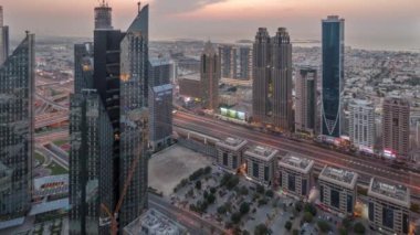 Dubai 'deki Sheikh Zayed Yolu' ndaki yüksek binalar. Gündüzden geceye geçiş panoramik zaman dilimi, BAE. Finans bölgesindeki gökdelenler. Arka planda evler ve villalar var.
