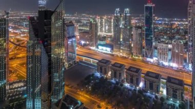 Dubai 'deki Sheikh Zayed Yolu' ndaki yüksek binalar tüm gece boyunca, BAE. Uluslararası finans bölgesindeki gökdelenler. Arka planda şehir yürüyüş evleri var. Ay batıyor