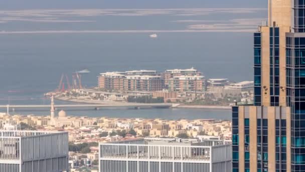 ダウンタウンのタイムラプスに近いドバイ市内のアパートやヴィラの空中ビュー 高層ビルの裏側をモスクで眺めます 人工島を背景に アラブ首長国連邦 — ストック動画