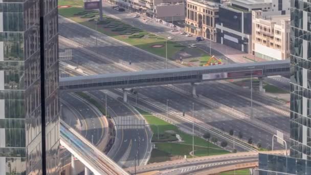 从上方俯瞰迪拜市区一个繁忙的交叉口的空中风景 五颜六色的汽车和卡车在谢赫扎耶德路上双向行驶 摩天大楼的长长的阴影 — 图库视频影像