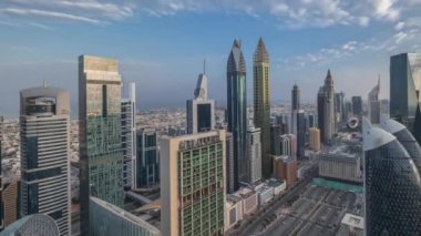 Güneşin doğuşundan batışına kadar tüm gün boyunca Dubai 'deki Sheikh Zayed Yolu' ndaki gökdelenlerin panoramik görüntüsü. Yukarıdan Uluslararası Finans Merkezindeki Gökdelenler