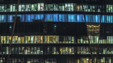 Kule binasının ön cephesinde, ışık zamanlaması olan bir sürü pencere var. Her pencerede hayat var. Finans bölgesinde bir ofis gökdelenin cam cephesinin havadan görünüşü.