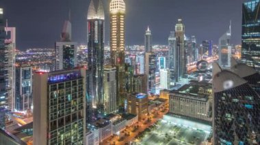 Dubai 'deki Sheikh Zayed Yolu' ndaki gökdelenlerin gökdelen manzarası. Tüm gece boyunca zaman ayarlı, BAE. Uluslararası Finans Merkezi 'nde yukarıdan aydınlatılmış gökdelenler. Işıklar kapanıyor.