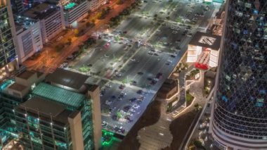 Dubai 'deki Sheikh Zayed Yolu' ndaki yüksek binalarla çevrili büyük otoparkın Skyline görüntüsü. Uluslararası Finans Merkezi 'nde yukarıdan aydınlatılmış gökdelenler