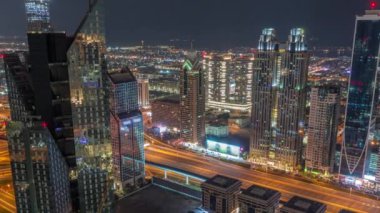 Dubai 'deki Sheikh Zayed Yolu' ndaki yüksek binalar gece uçuşları sırasında, BAE. Finans bölgesinin gökdelenleri. Arka planda şehir yürüyüş evleri. Aydınlanma kapanıyor