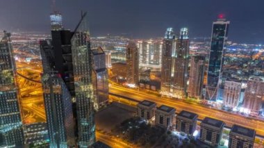 Dubai 'deki Sheikh Zayed Yolu' ndaki yüksek binalar gece gündüz geçiş zamanları, BAE. Uluslararası finans bölgesindeki gökdelenler. Arka planda evler ve villalar var.