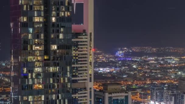 ドバイ市内のアパートやヴィラの空中ビューダウンタウンの夜のタイムラプス近く 金融街の高層ビルの窓を点滅させます アラブ首長国連邦 — ストック動画