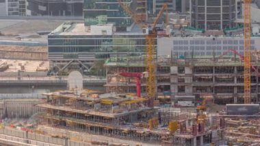 Çalışan vinçleri ve kazıcı zaman ayarları olan büyük bir inşaat alanı. Business Bay, Dubai 'deki büyük yerleşim ve ofis alanının en iyi hava manzarası