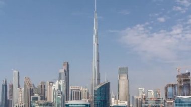 Dubai Business Bay ve şehir merkezinin havadan görüntüsü. Kanal zamanındaki çeşitli gökdelenler ve kuleler. Vinçleri olan bir inşaat alanı. Gölgeler hızlı hareket ediyor