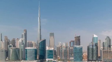 Dubai Business Bay ve şehir merkezinin havadan görüntüsü. Kanal zamanındaki çeşitli gökdelenler ve kuleler. Vinçleri olan bir inşaat alanı. Gökyüzündeki bulutlar