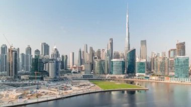 Dubai Business Bay ve şehir merkezinin havadan görüntüsü. Kanal zamanındaki çeşitli gökdelenler ve kuleler. Vinçleri ve ağır makineleri olan büyük bir inşaat alanı.