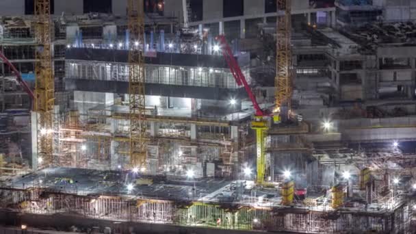 大型建筑工地 有许多工作起重机和工人在统一的夜间时间 迪拜商业区住宅及办公区大型发展的高层航景 — 图库视频影像