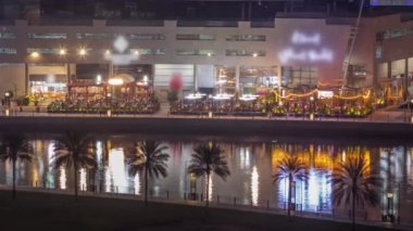 Dubai 'nin Business Bay bölgesindeki birçok kalabalık restoranın bulunduğu su kanalı boyunca yürüme mesafesinde. Rıhtımda köprüler, yukarıdan gökdelenler, Birleşik Arap Emirlikleri
