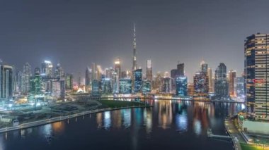 Dubai Business Bay ve şehir merkezinin havadan görüntüsü. Kanal boyunca çeşitli gökdelenler ve kuleler var. Vinçli inşaat alanı