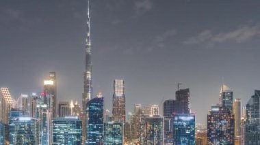 Dubai Business Bay ve şehir merkezinin havadan görüntüsü. Kanal boyunca çeşitli gökdelenler ve kuleler var. Vinçleri olan bir inşaat alanı. Sudaki yansıma