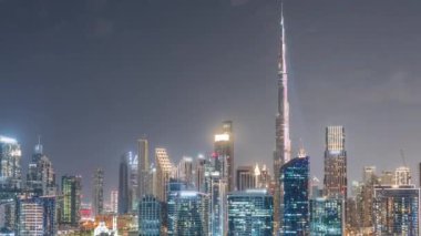 Dubai Business Bay ve şehir merkezinin havadan görüntüsü. Kanal boyunca çeşitli gökdelenler ve kuleler var. Adada vinçleri olan bir inşaat alanı.