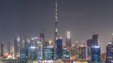 Tüm gece boyunca Dubai Business Bay ve Downtown 'ın havadan görüntüsü. Kanal boyunca çeşitli gökdelenler ve kuleler var. Vinçli inşaat alanı