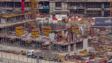 Çalışan vinçleri olan büyük bir inşaat alanı. Business Bay, Dubai 'deki büyük yerleşim ve ofis alanının en iyi hava görüntüsü. Buldozer ve kamyon.