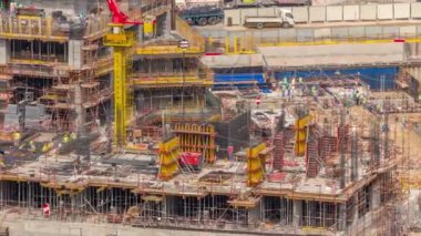 Çalışan vinçleri olan büyük bir inşaat alanı. Dubai 'deki Business Bay' de çok sayıda işçinin bulunduğu yerleşim ve ofis bölgesinin büyük gelişimi için üst düzey hava görüntüsü