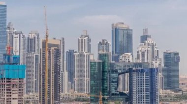 Dubai İşletme Koyu 'nun gökdelenleri ve su kanallarının zaman çizelgesi olan şehir manzarası. Modern gökyüzü ve caminin yakınındaki ofis kuleleri. Yeni bloğun inşaat alanı.