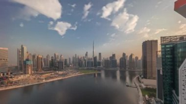 Gün doğumundan günbatımına kadar tüm gün boyunca Dubai Business Bay ve Downtown 'da hava panoramik görüntüsü. Kanal zamanındaki liman boyunca çeşitli gökdelenler ve kuleler. Vinçli inşaat alanı
